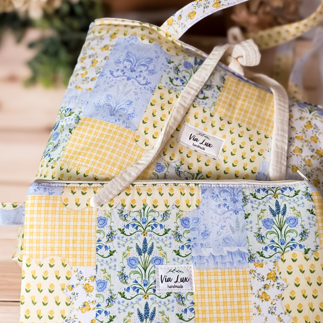 Patchwork baby bag with floral and gingham patterns, featuring 'Via Lux' branding.