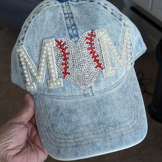 Denim cap with 'MOM' embellishments held by a hand/ Baseball rhinestones