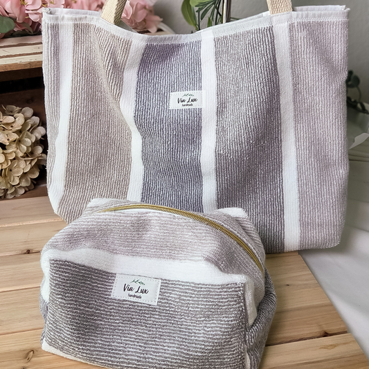 Two striped bags with a visible brand label on a wooden surface.