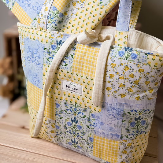Patchwork tote bag with floral patterns on a wooden surface
