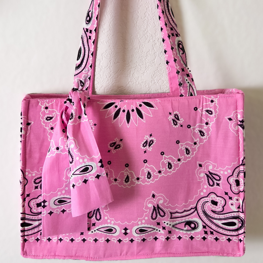 Pink tote bag with black bandana pattern on a white background